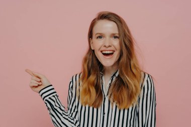 Gülen genç bir kadın işaret parmağıyla reklam için fotokopi alanını işaret ediyor.