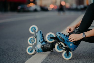 Tanınmayan kadın bacakları paten giyer açık havada egzersiz yapar sokak yollarında paten yapmaya hazırlanır. Yüzsüz patenci tehlikeli sporlara gider.