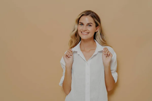 Joven mujer guapa feliz con el pelo teñido rubio en camisa blanca sonriendo alegremente — Foto de Stock