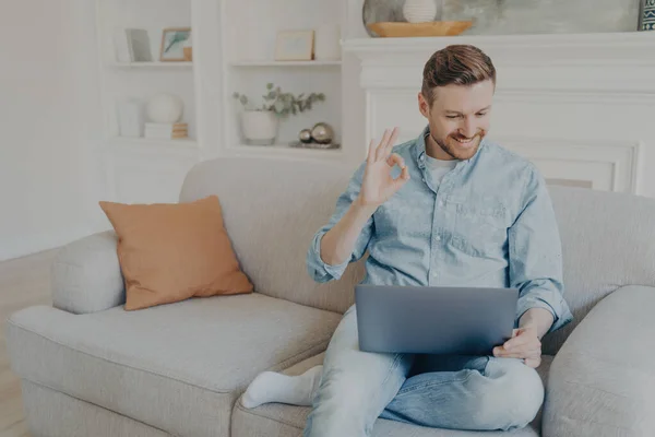 Przystojny biały mężczyzna freelancer uśmiechnięty podczas rozmowy online z szefem na laptopie — Zdjęcie stockowe