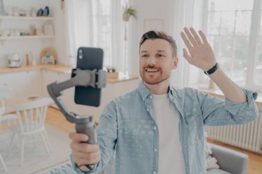 Genç yakışıklı blogcu akıllı telefondan video blogu yapıyor