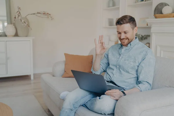 Молодий офіс чоловік працівник показує нормальний жест під час онлайн-зустрічі вдома — стокове фото