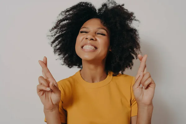 Huvudet sköt leende vacker afrikansk flicka med slutna ögon korsande fingrar önskar lycka till — Stockfoto