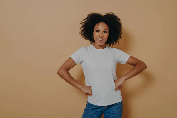 Belle femme afro-américaine confiante portant des vêtements élégants décontractés gardant les mains sur les hanches — Photo