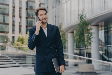Yakışıklı, tıraşsız erkek girişimci iş arkadaşları veya ortaklarıyla uzaktan iletişim kurar