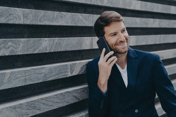 Atraente jovem trabalhador de escritório em blazer elegante falando no telefone celular fora — Fotografia de Stock