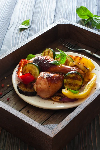 Grillade kycklingklubbor med grönsaker i trä facket — Stockfoto