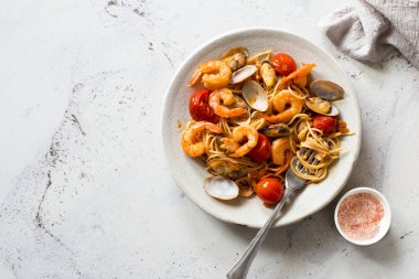 Domates soslu İtalyan makarnası, deniz tarağı ve karides gri taş levha. Düz yatıyordu. Boşluğu kopyala