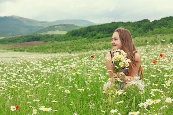 Portrait of smiling 10-years old girl with flowers — Stock Photo, Image