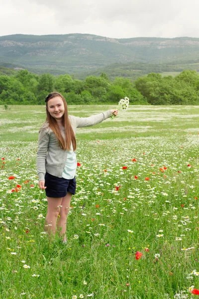 Miúdo menina colhendo flores no prado — Fotografia de Stock