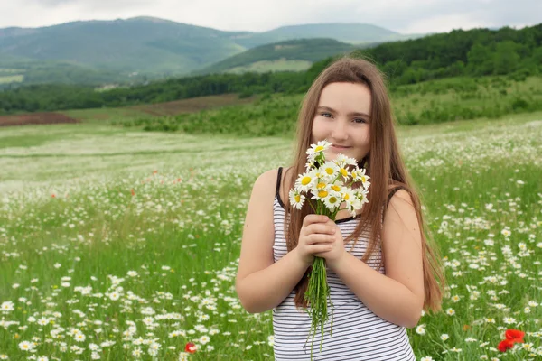 10 let stará dívka s květinami se usmívám — Stock fotografie