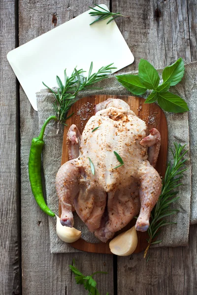Nyers egész csirke, a zöldségek, a fa tábla — Stock Fotó