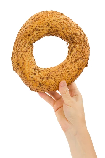 Mão feminina segurando bagel fresco, isolado em fundo branco — Fotografia de Stock