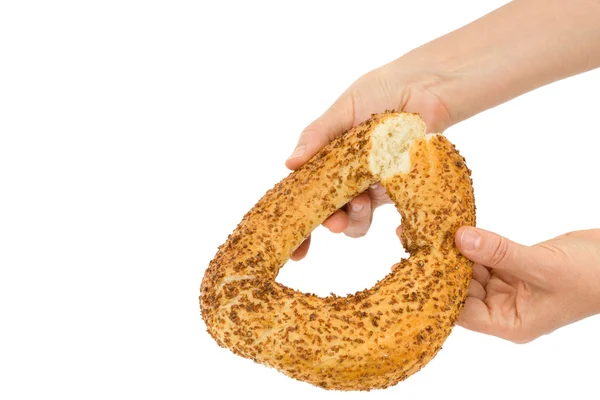 Las manos femeninas rompen un bagel, aislado sobre fondo blanco —  Fotos de Stock