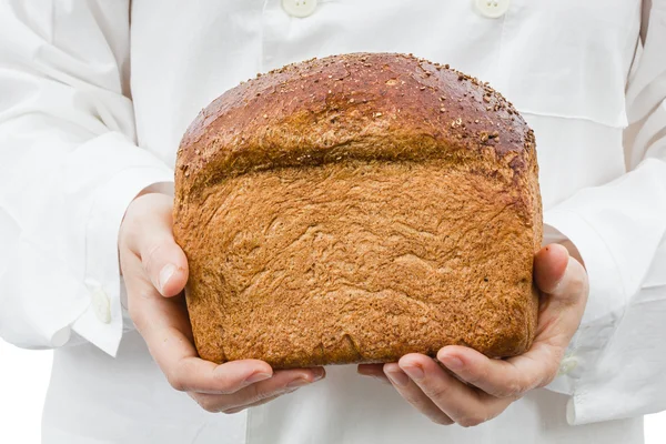 Пекарь держит в руках свежий хлеб — стоковое фото