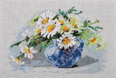 Nakışlı bir resim, vazoda bir buket çiçekle hayat, tekstil tuvalinde çapraz dikiş, beyaz arka planda izole edilmiş.