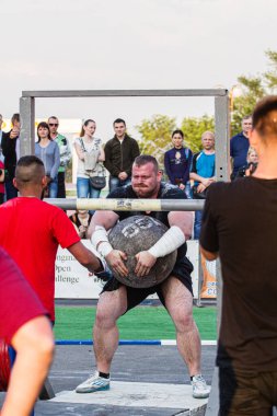 Melitopol, Ukrayna, tarih 27 Mayıs 2017, Strongman direğe ağır bir taş topu fırlattı.