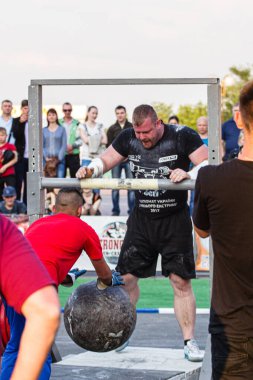 Melitopol, Ukrayna, tarih 27 Mayıs 2017, Strongman direğe ağır bir taş topu fırlattı.