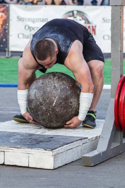 Melitopol, Ukrayna, tarih 27 Mayıs 2017, Strongman ağır bir taş topu kaldırdı