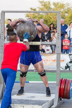 Melitopol, Ukrayna, tarih 27 Mayıs 2017, Strongman direğe ağır bir taş topu fırlattı.