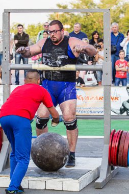 Melitopol, Ukrayna, tarih 27 Mayıs 2017, Strongman direğe ağır bir taş topu fırlattı.