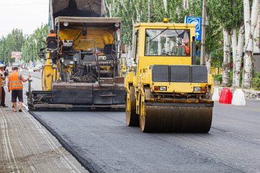 Melitopol, Ukrayna, tarih 27 Mayıs 2017. Pist yol yüzeyini sıkıştırıyor, caddede yol onarımı yapılıyor.