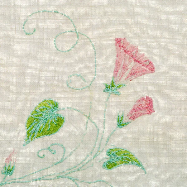 Ornament from embroidered flowers, cross-stitch on textile canvas