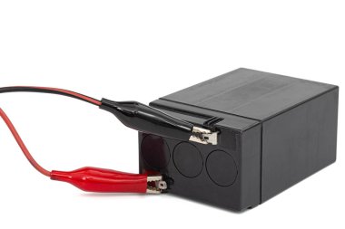 Beyaz zemin üzerinde izole edilmiş iğnelere bağlı kablolarla asit doldurulabilir batarya paketi