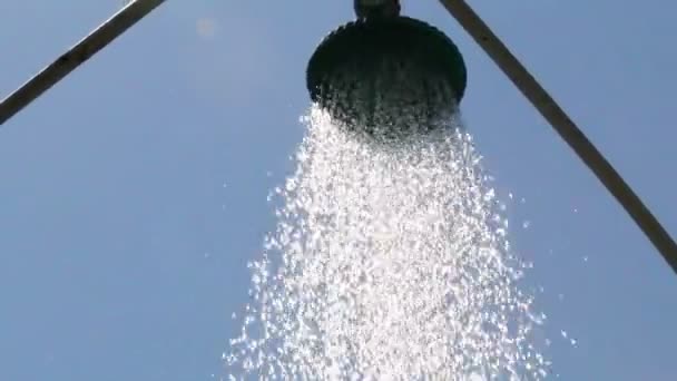 Вода льется из душа на голубое небо — стоковое видео