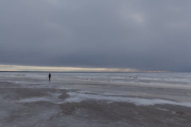 Kışın Parnu sahilinde yalnız bir siluet, Estonya