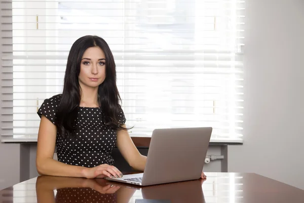 Ділова жінка використовує ноутбук в офісі — стокове фото