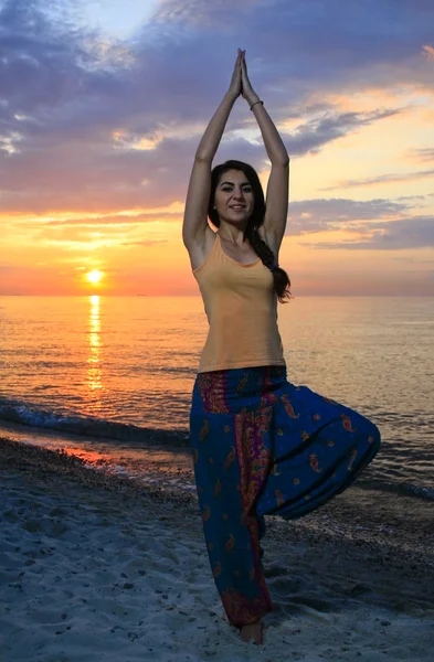 Meisje doet yoga op het strand. — Stockfoto