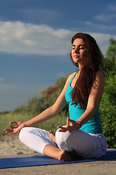 Flicka gör yoga på stranden. — Stockfoto