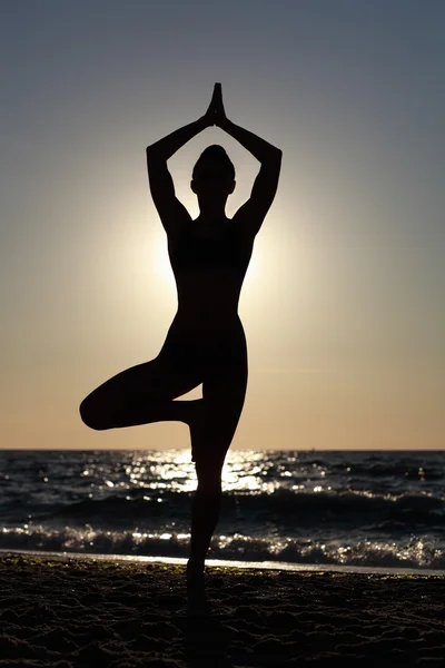 Meisje doet yoga op het strand. — Stockfoto