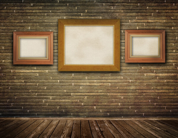 Three old-fashioned frames on a bricks wall.