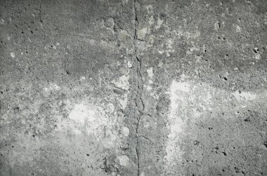 Eski beton bir duvarın dokusu, alçı kalıntıları ve geniş bir çatlak..