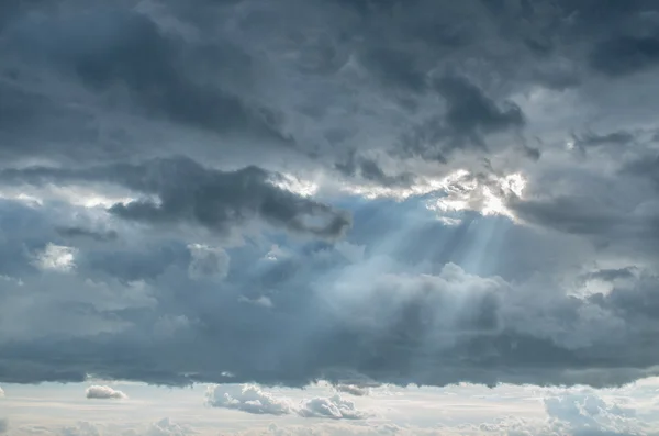 Lichtstraal tegen bewolkte hemel — Stockfoto