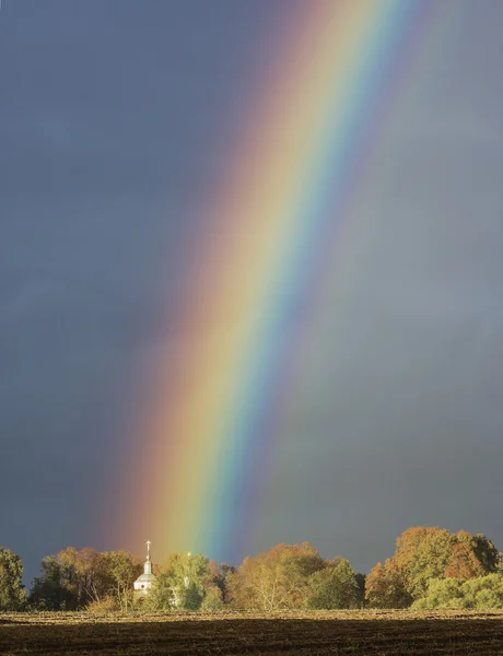 Rainbow over a church — Stock Photo, Image