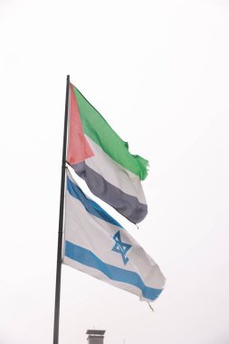 Bir İsrail ve Filistin bayrağı rüzgarda birlikte barış ve beraberliğin sembolü ve iki devletten oluşan bir çözüm olarak