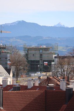Arka planda çatılar ve dağlar tarafından çerçevelenmiş bir inşaat alanının görüntüsü. Kempten 'de