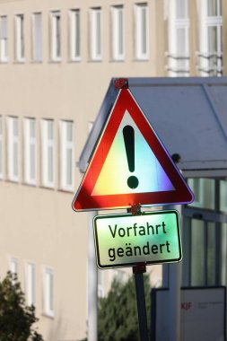 Close-up of a traffic sign that indicates a change in right of way, with clear graphics and vibrant colors.