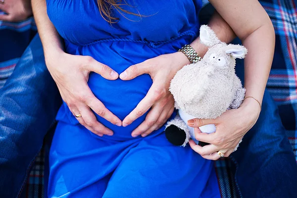 Gravid mage med fingrar hjärta. — Stockfoto