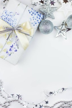 Bayram havası, tatil hazırlığı. Gümüş renkli dekorlu Noel hediyesi kutusu. Oyuncak, yıldız, yuvarlak toplar.