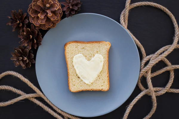 Бутерброд Завтрак Виде Сердца Сыром Голубой Тарелке Черным Фоном Конусами — стоковое фото