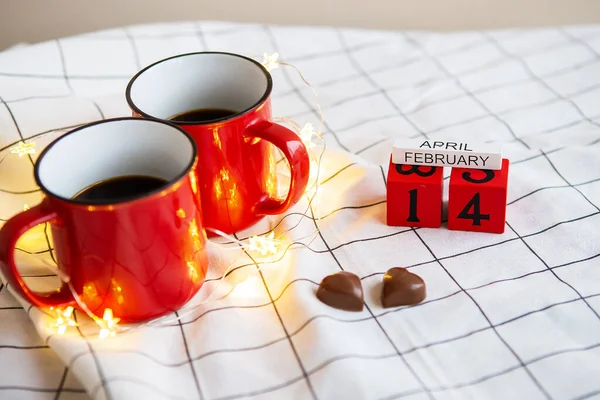 Kalp Şeklinde Çikolata Kanfeti Arkaplanında Kırmızı Bardakta Iki Fincan Kahve — Stok fotoğraf