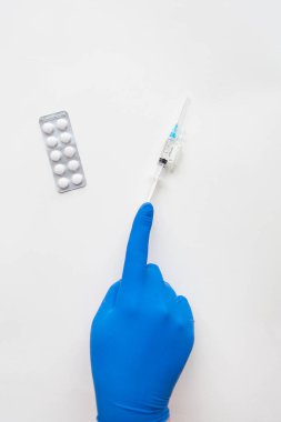 Aşıya hazırlanıyorum, mavi eldivenli doktor, haplar ve aşılı bir şırınga. Coronavirus, covid-19 aşısı.