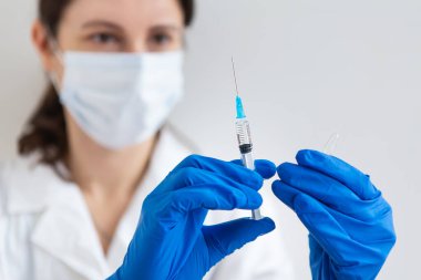 Yeni Coronavirus COVID-19.2019-nCoV konsepti. Doktorun elinde aşı olan şırınga, yakın plan.