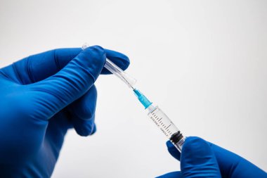 Doktorun eli mavi eldivenlerle aşıya hazırlanıyor. Coronavirus, covid-19 aşısı.