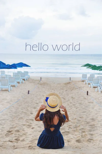 戴帽子的美女坐在沙滩上 你好世界 — 图库照片