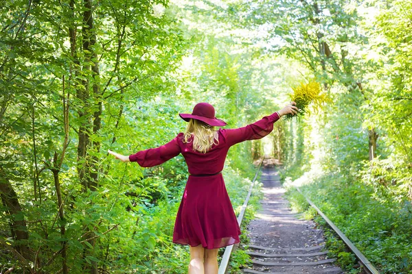 Mädchen Das Mit Einem Strauß Gelber Blumen Auf Den Gleisen — Stockfoto